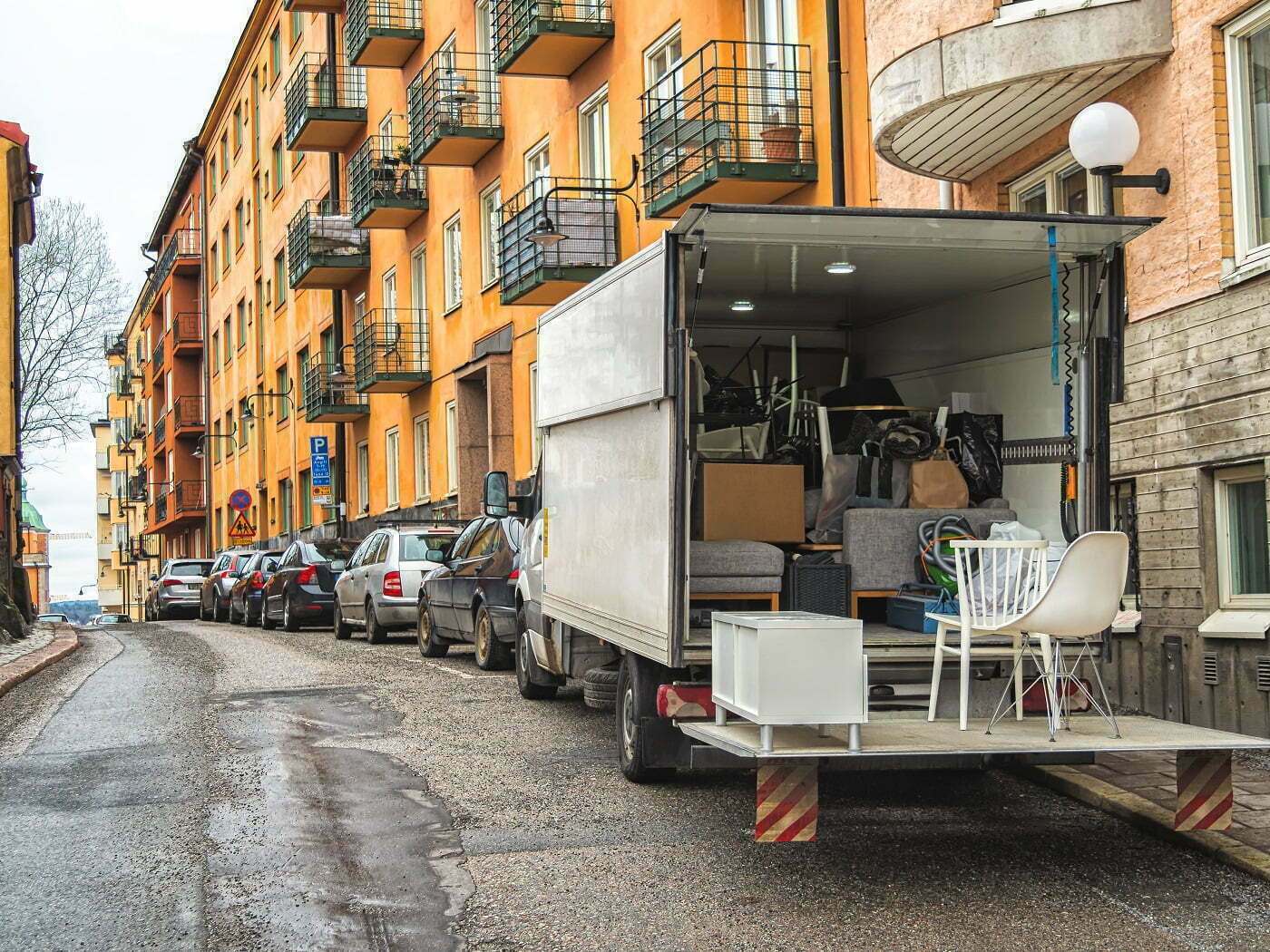 Kuvassa lastattu muuttoauto kerrostaloasuntojen edessä.